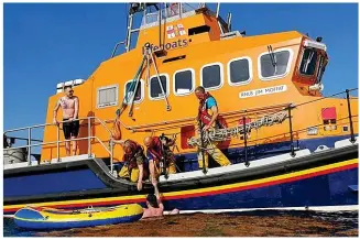  ??  ?? Rescued: Lifeboat crew pluck a man to safety from a dinghy off Troon