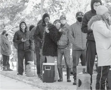  ?? JAY JANNER/AUSTIN AMERICAN-STATESMAN ?? People wait in line to fill up containers with water Friday at the Meanwhile Brewing Company in Austin, Texas. The state’s capital city is under a boil-water notice after this week’s deadly winter storm.