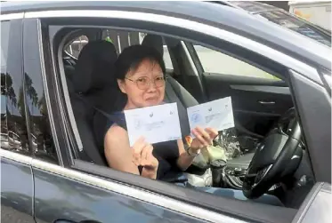  ?? ?? Not taking any chances: Tan showing the postal votes she will be driving back from singapore to Johor.