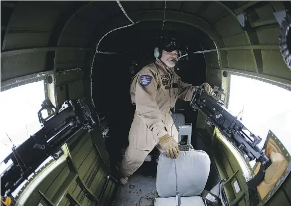  ?? DAVID BLOOM ?? Flight load master John Roberts looks out the window of a B-25J Mitchell bomber during a fly-along at Villeneuve Airport on Friday.