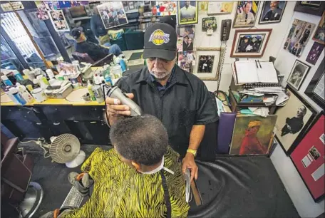  ?? Photograph­s by Jason Armond Los Angeles Times ?? LAWRENCE TOLLIVER cuts the hair of Joseph Kenery on Monday, when much of the talk was about Kobe Bryant. Ref lecting on the Lakers star’s effect on fans, Tolliver said, “it didn’t dawn on me until now how much this generation really loved and idolized him.”