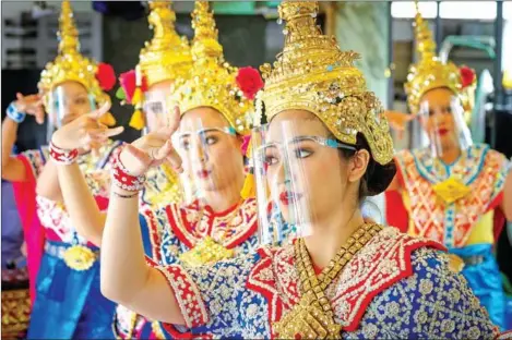  ?? AFP ?? Traditiona­l Thai dancers wearing protective face shields perform at the Erawan shrine, which was reopened after the Thai government relaxed measures to combat the spread of the Covid-19 novel coronaviru­s, in the Thai capital Bangkok on Monday.