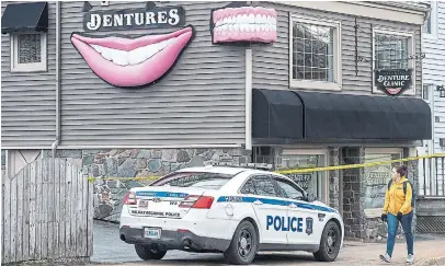  ?? ANDREW VAUGHAN THE CANADIAN PRESS ?? Police guard the Atlantic Denture Clinic in Dartmouth, N.S., owned by the man responsibl­e for the Nova Scotia mass shooting. The toothy-grin signs have since been taken down after an online petition garnered roughly 7,000 signatures in two days.