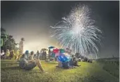  ?? MICHAEL LAUGHLIN/SUN SENTINEL ?? A large crowd watches fireworks pop in the sky above Boca Raton’s Countess De Hoernle Park in 2018.