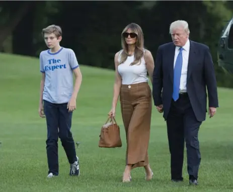  ?? CHRIS KLEPONIS-POOL/GETTY IMAGES ?? HOME FOR THE HOLIDAYS U.S. President Donald Trump, his wife, Melania, and their 11-year-old son Barron arrive at the White House on Sunday. Melania and Barron, who lived at Trump Tower in New York while Barron was in school, have now officially moved...