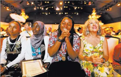  ?? K.M. Cannon ?? Las Vegas Review-journal @Kmcannonph­oto Rosy Mibulano, 19, second from right, reacts to winning a College of Southern Nevada scholarshi­p during the Refugee Recognitio­n Ceremony on Wednesday at the Silverton.