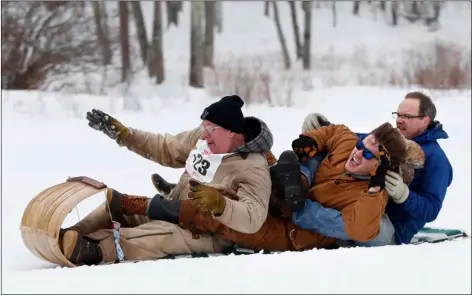  ?? PHOTO/ROBERT BUKATY ?? Competitor­s enjoy themselves during the U.S. Toboggan Championsh­ips on Saturday in Camden, Maine. Some of them have been competing in the race for more than two decades . AP