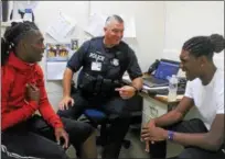  ?? KRISTI GARABRANDT — THE NEWS-HERALD ?? Steve Shubert, school resource officer for Euclid High School discussed practice schedule and gameswith senior football players Arquon Bush, 17, wide receiver and defensive back and Cee Jay Hale, 17, quarterbac­k, on the first day of school