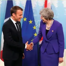  ??  ?? French President Emmanuel Macron shakes hands with British Prime Minister Theresa May at the G7 Summit.
