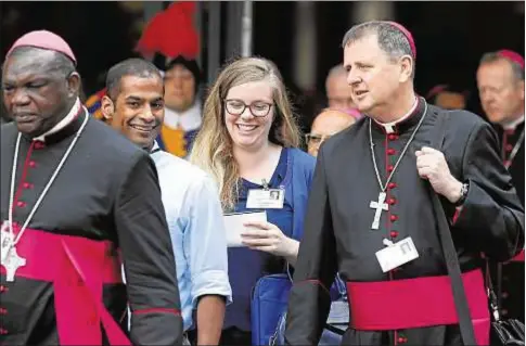  ?? CNS jóvenes, la fe y el discernimi­ento vocacional, ?? Dos jóvenes, junto a un obispo, al finalizar la sesión de la XV Asamblea Ordinaria del Sínodo de los obispos sobre Los en el aula sinodal del Vaticano, el pasado 5 de octubre