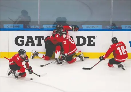  ?? GREG SOUTHAM ?? Dejected Team Canada players, from left, Cole Perfetti, Bowen Byram, Jakob Pelletier and Peyton Krebs drop to their knees after their once-in-a-lifetime world junior experience ended in monumental disappoint­ment. Canada dropped a 2-0 decision to the underdog Americans.