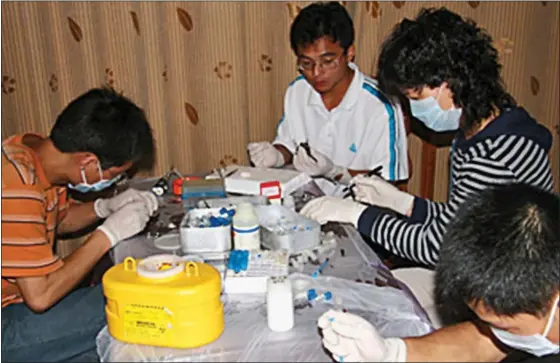  ??  ?? EXPOSURE: The Wuhan scientists wear little in the way of personal protective equipment as they take samples from the bats before releasing them
