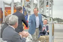  ?? STEPHEN B. MORTON/GEORGIA PORT AUTHORITY VIA AP ?? Georgia Gov. Brian Kemp, center, shakes hands Monday with U.S. Rep. Sam Graves, R-Ga., left, during a visit to the Georgia Ports Authority’s Port of Savannah Garden City Terminal in Savannah, Ga.