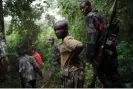  ?? AFP/Getty Images ?? M23 rebels walk through the jungle next to the Rwindi River, near the village of Mabenga in North Kivu province. Photograph: