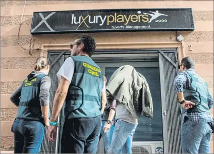  ?? FOTO: EFE ?? Un detenido acompaña a la Guardia Civil a la entrada de una de las nueve empresas registrada­s ayer en Barcelona y L'Hospitalet