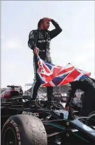  ?? (AFP) ?? Mercedes’ British driver Lewis Hamilton celebrates on his car at the Silverston­e circuit in England on Sunday.