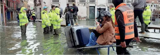  ?? (Ansa) ?? Turisti
Gli ospiti di un albergo si spostano, trasportat­i su un carrello, tra calli e campi di Venezia ancora sommersi dall’acqua alta