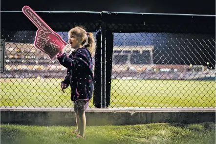  ?? PHOTOS BY CRAIG FRITZ/FOR THE NEW MEXICAN ?? Kira Trujillo, 5, cheers Tuesday for the Isotopes from the outfield lawn of Isotopes Park during the season’s first home game. The Isotopes beat visiting Las Vegas 7-3 in front of 9,104 fans.