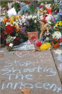  ?? Associated Press photo ?? A photo of Tree of Life Synagogue victim Jerry P. Rabinowitz is surrounded Monday by flowers, part of a spontaneou­s memorial of flowers and sidewalk writing, a block from the temple were a shooter shot and killed Rabinowitz and 10 other people as they worshipped Saturday in Pittsburgh.