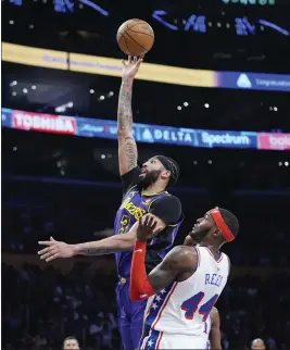  ?? JAE C. HONG — THE ASSOCIATED PRESS ?? The Lakers' Anthony Davis goes up for a basket as the 76ers' Paul Reed defends during Friday night's game. Davis had 23points and 19rebounds in the Lakers' victory.