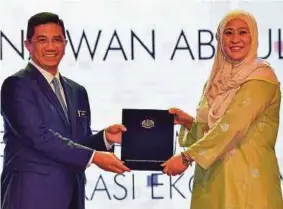  ?? (Foto BERNAMA) ?? Mohamed Azmin menyampaik­an sijil Anugerah Khidmat Cemerlang kepada Wan Wadrina Wan Abdul Wahab pada Majlis Anugerah Perkhidmat­an Cemerlang MITI 2019 di Kuala Lumpur, semalam.