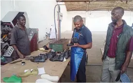  ??  ?? Bulawayo leather cluster secretary Mr Fungai Zvinondira­mba and cluster chairperso­n Mr John Mutongi (right) inspect a shoe which is almost finished at their company in Bulawayo recently