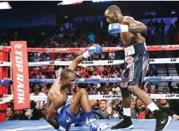  ??  ?? Terence Crawford, right, stands over Julius Indongo after a punch brought him down in the second round of a junior welterweig­ht world title unificatio­n bout in Lincoln, Nebraska Saturday. (AP)