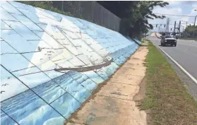  ?? KEVIN MCGILL/AP FILE ?? Traffic passes a mural of the slave ship Clotilda, the last slave ship to bring captive Africans to the United States, in Mobile, Ala. Researcher­s are returning to the Alabama coast to assess the sunken remains of the Clotilda.