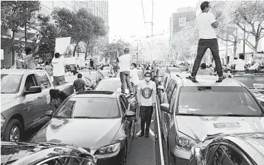  ?? JIM WILSON/NYT ?? People gather outside Uber’s headquarte­rs in San Francisco in October to urge voters to reject California’s Propositio­n 22.