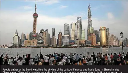  ?? — EPA. ?? People gather at the Bund watching the skyline of the Lujiazui Finance and Trade Zone in Shanghai city, China, years. China will complete an audit of the debt this month to assess risks to its financial system.