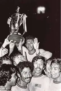  ?? NST PIC ?? A file picture of the late M. Chandran celebratin­g with teammates by holding the Merdeka Cup trophy in 1973.