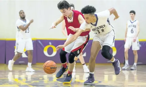  ?? JULIE JOCSAK/STANDARD STAFF ?? Tyrell MacLennon of the St. Francis Phoenix, right, and Nick Pasaluko of the Blessed Trinity Eagles fight for the ball in Day 1 of Standard High School Basketball Tournament action on Monday.