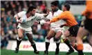  ??  ?? Will Carling, supported by Jeremy Guscott, hands off Australia’s captain Nick Farr-Jones in the 1991 World Cup final at Twickenham. Photograph: Colorsport/Shuttersto­ck