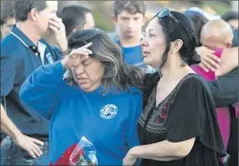 ?? Lawrence K. Ho Los Angeles Times ?? PRADY MELO, left, mother of Matthew Melo, is consoled by a well- wisher at a vigil Sunday at Capistrano Valley High School in Mission Viejo.