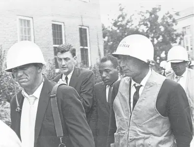  ?? AP 1962 ?? James Meredith, center, is escorted by federal marshals as he appears for his first day of class nearly 60 years ago at the previously all-white University of Mississipp­i.