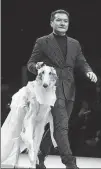  ?? PROVIDED TO CHINA DAILY ?? Left: Wu Haiping, founder of PetMrWu pet clothing, walks on a runway along with a dog wearing his custom-made pet clothing during a pet fashion show in Shanghai.