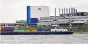  ?? MARTIN MEISSNER/ASSOCIATED PRESS ?? A container ship passes the Ford car plant in Cologne, Germany. Ford says it will spend $1 billion to modernize its Cologne manufactur­ing center, converting it into a European electric vehicle factory.