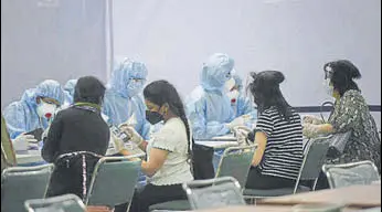  ?? VIPIN KUMAR/HT PHOTO ?? Medical staff in personal protective equipment (PPE) hand out advisories to Indians evacuees from Singapore at Indira Gandhi Internatio­nal Airport in New Delhi on Friday.
