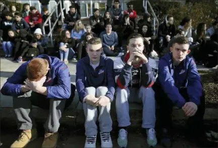  ?? CRAIG F. WALKER — THE BOSTON GLOBE VIA AP ?? In this photo, Somerville High School students sit on the sidewalk on Highland Avenue during a student walkout at the school in Somerville, Mass. A large-scale, coordinate­d demonstrat­ion is planned for Wednesday, March 14, when organizers have called...