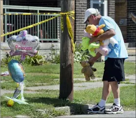  ?? GREG WOHLFORD — ERIE TIMES-NEWS VIA AP ?? Paul Laughlin, 57, places stuffed animals on Sunday outside a home at 1248 West 11th St. in Erie, Pa., where multiple people died in an early-morning fire.