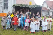  ?? FOTO: FRANK DECHERT ?? Das evangelisc­he Krippenspi­el-Team hat mit 28 Kindern und Pfarrer Peter Steinle ein modernes Krippenspi­el auf der Kirchwiese gezeigt.
