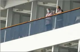  ?? The Canadian Press ?? Passengers look out from the Zaandam cruise ship anchored in the bay of Panama City, Friday. Four passengers have died aboard the cruise ship.