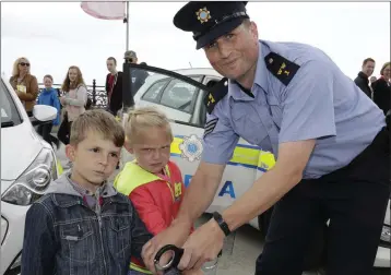  ??  ?? Kevin Kapacinska­s and Vanessa Teriajeva getting cuffed by Sgt John Fitzpatric­k at the Garda display and informatio­n day at the Seafront