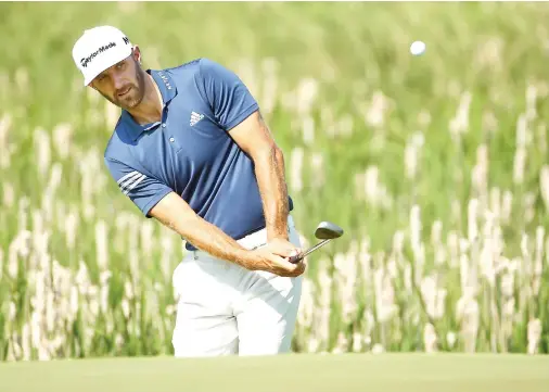  ??  ?? Defending champion Dustin Johnson chips up to the first green during a practice round of the US Open golf tournament at Erin Hills on Tuesday. (USA TODAY Sports)