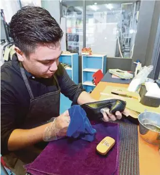  ??  ?? Ridhwan menunjukka­n cara proses mencuci kasut yang dihantar pelanggan.