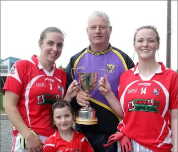  ??  ?? Denis Nolan (Co. Chairman) presenting the cup to joint captains Stephanie Foley and Eimear Mullan with the help of Chloe Foley.