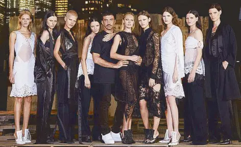  ??  ?? Givenchy designer Riccardo Tisci flanked by models wearing spring 2016