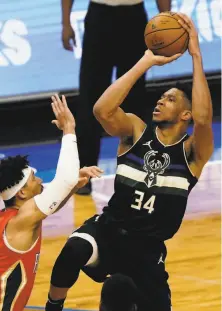  ?? Morry Gash / Associated Press ?? Milwaukee’ Giannis Antetokoun­mpo leans back for a jumper over New Orleans’ Josh Hart on his way to 38 points.