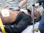  ??  ?? The Westminste­r car and knife attacker, seen here receiving emergency treatment from paramedics, has been named as Khalid Masood, 52. Last night it emerged his real name was Adrian Elms