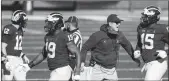  ?? Detroit Free Press/tns ?? Michigan head coach Jim Harbaugh high-fives defensive players against Penn State on Nov. 28, 2020.